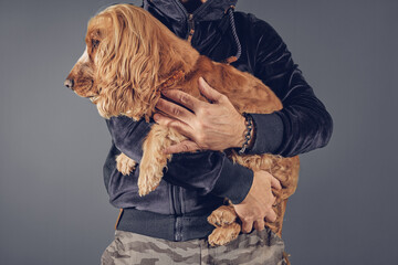 Man holding cocker spaniel dog in arms