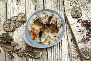 hums with grilled eggplant on a gray plate on a gold background
