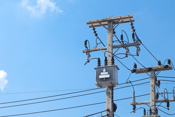 Cement high voltage electric pole power with transformer and drop fuse and blue sky copy space.