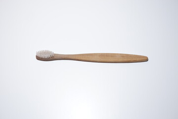 photo of a toothbrush with a wooden handle. very minimalist and aesthetic