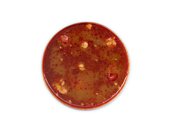 Above view of Nam ngiao made from pork and pick pork inside white cup. On isolated white background with clipping path.