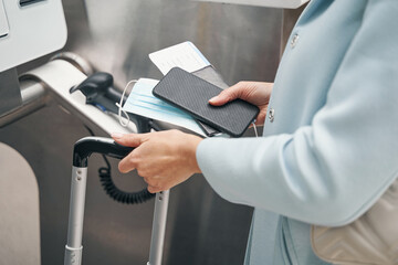 Passenger with baggage and travel documents at airport terminal