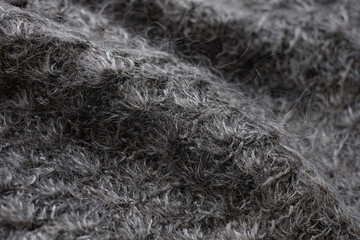 Dark gray woolen natural texture, knitted textile background, close-up