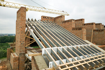 Fototapeta na wymiar Unfinished brick apartment building with wooden roof structure under construction