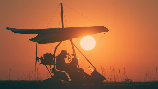 The preparing for testing flight by hang glider on beautiful sunset background