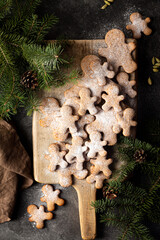 christmas gingerbread cookies on the dark background with branches of Christmas tree 