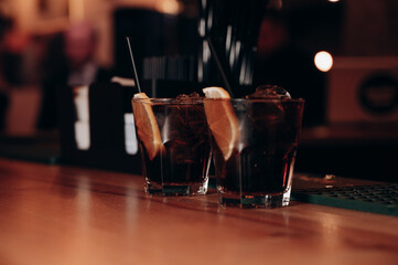 two cocktails in a beautiful glass stands on a wooden table