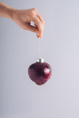 Female hand holding Christmas bauble decoration. Minimal natural holidays concept. Green New Year's Resolution