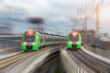 Fototapeta premium Two city passenger railway trains cross the bridge and turn at high speed.