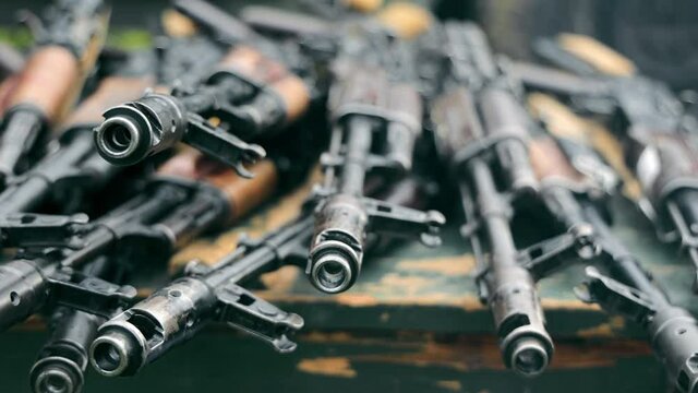 Submachine guns and other weapons are in storage. The barrel of a machine gun close up. Weapon storage.