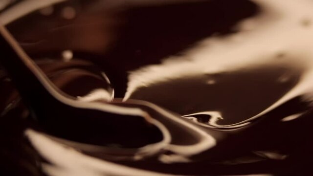 spoon stirs melted chocolate in slow motion.
macro shot 120 fps