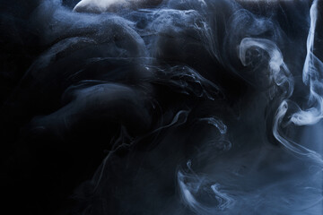 Dark Blue smoke on black ink background, colorful fog, abstract swirling indigo ocean sea, acrylic paint pigment underwater © amixstudio
