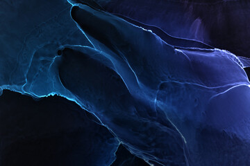 Abstract blue electric wave on black technology background. Neon light paint in water, acrylic...