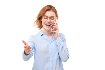 Joyful smiling redhead girl talking smartphone in spectacles and business shirt isolated on white studio background