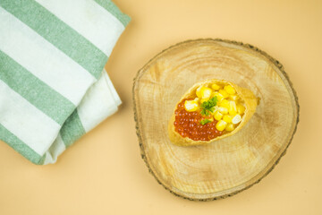 Fried tofu stuffed with rice and topping with fish roe and corn