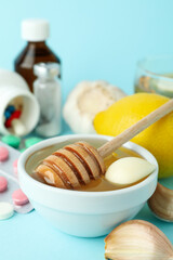 Concept of treatment colds with honey and garlic on blue background