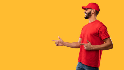 Delivery Worker Pointing Finger Aside Showing Empty Space, Yellow Background