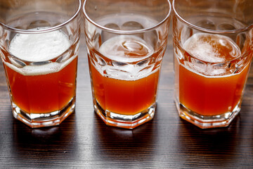 Glasses of beer are in the bar on the bar counter.