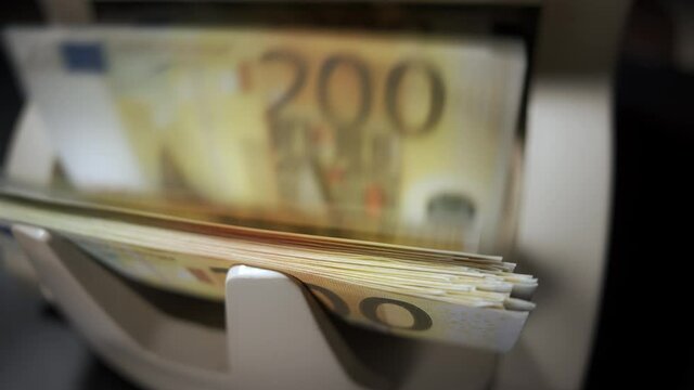 Money counting machine. 200 euro banknotes on a counter. Modern bank equipment is processing euros currency. Automatic operations of cash. Banking or commercial activity and investment concept