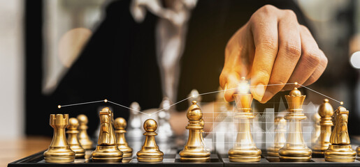 Person holding golden chess pieces to run a game, conceptual image of businessman playing...