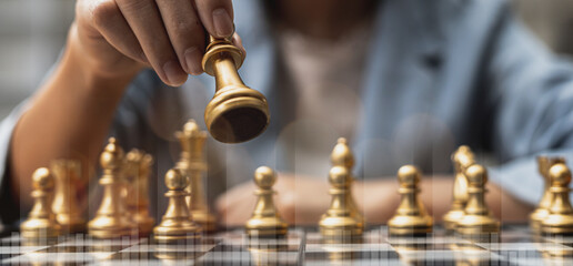 Person holding golden chess pieces to run a game, conceptual image of businessman playing chessboard compared to managing a business on risk, chart graphics showing financial flows.