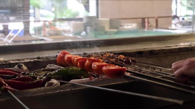 Cooking kebab in front of grill