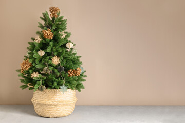 Eco Christmas tree in wicker basket decorated dry flowers and natural materials, paper DIY toys on beige background. Xmas greeting card with copy space.