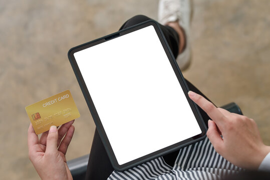 Close-up image of woman hands using tablet blank white screen and holding credit card. Online shopping concept.