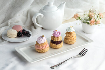Assorted Miniature French Choux Pastry Dessert with teapot on the table
