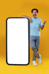 Excited guy leaning on empty smartphone screen and gesturing yes