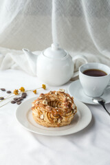 Caramel nut choux pastry Rings with Cream Filling and cup of tea on the table