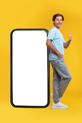 Happy man showing white empty smartphone screen and like