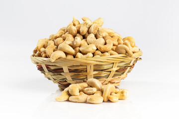Cashew nuts in a wicker bowl. Isolated on white.