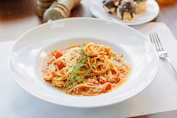 Spaghetti pasta with tomatoes and shrimps in a restaurant of italian food