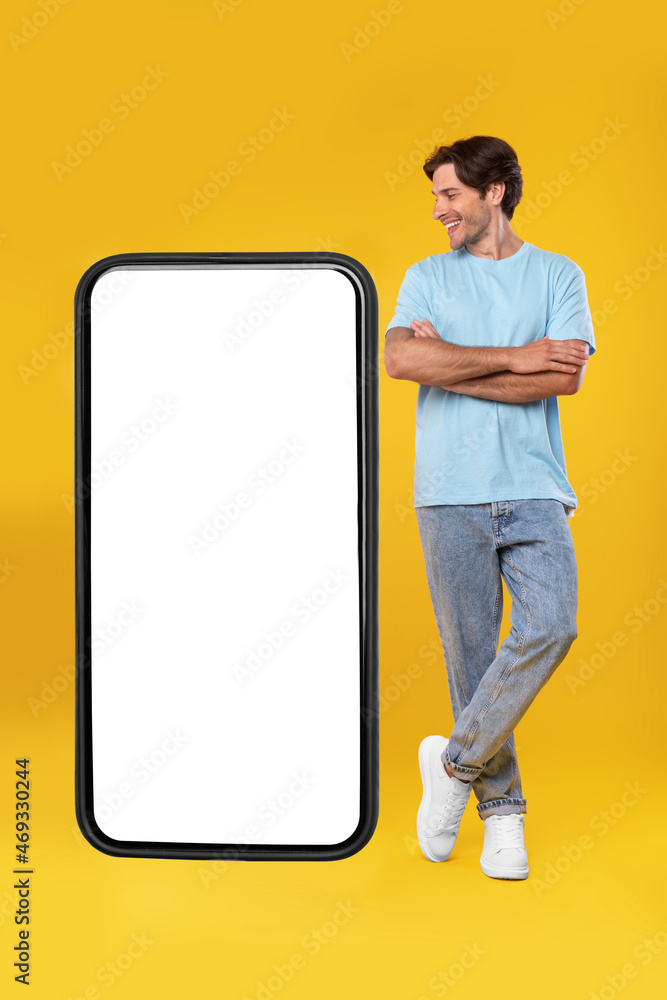 Poster guy standing near big empty smartphone screen with crossed hands