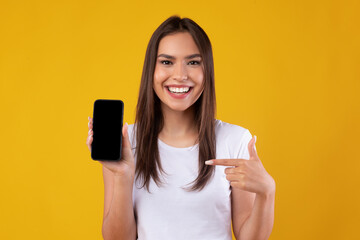 Happy woman pointing at white empty smartphone screen