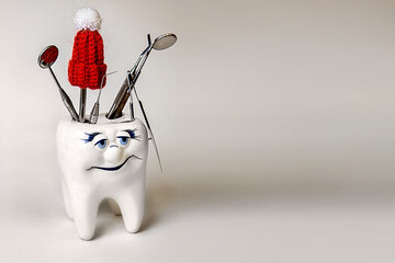 New Year. Christmas. stomatology. a figurine of a tooth in a santa claus hat and dentist tools