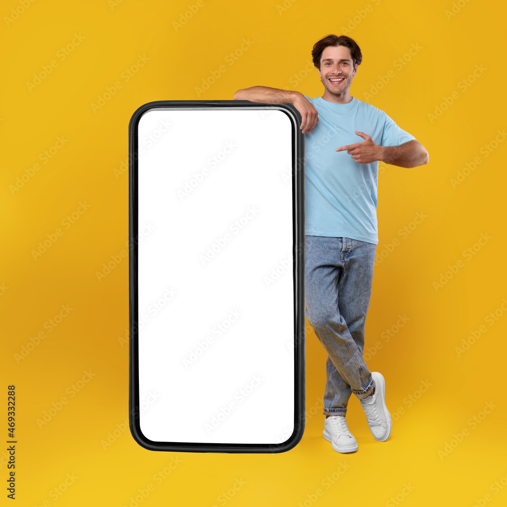Poster man pointing at big white empty smartphone screen, mockup