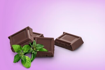 Milk chocolate and mint leaves on the desk