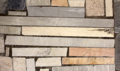 Pieces of different stones of different shapes in the wall