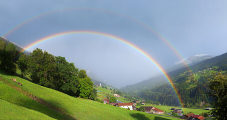 double rainbow over Saas village and green valley, prattigau switzerland landscape