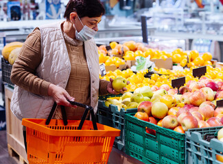 senior old woman shopping and choosing groceries in a supermarket . Pandemic coronavirus covid 19