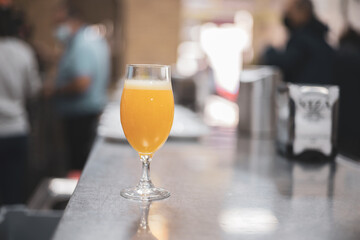a glass of orange juice in a bar in a cafeteria.