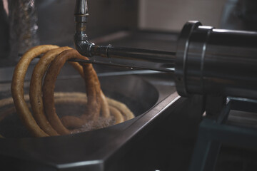 a woman picking churros to prepare them to go.