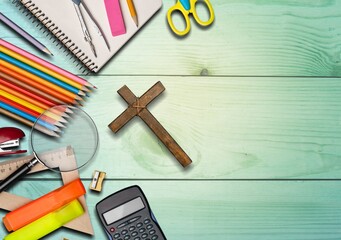 Office or school supplies with Christian cross on the desk