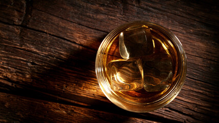 Top shot of whisky glass with ice cubes, closeup.