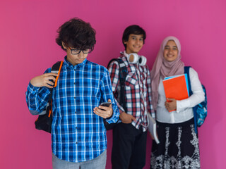 A group of Arab teenagers, a student team walking forward into the future and back to school the concept of a pink background. The concept of successful education for young people. Selective focus