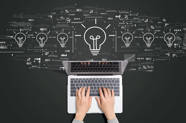 Idea light bulb theme with person using a laptop computer