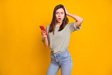 Portrait of attractive worried girl using gadget browse fake news reaction smm isolated over bright...