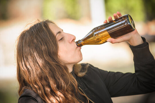 Girl chug bottle beer. Express drinking and fast get drunk